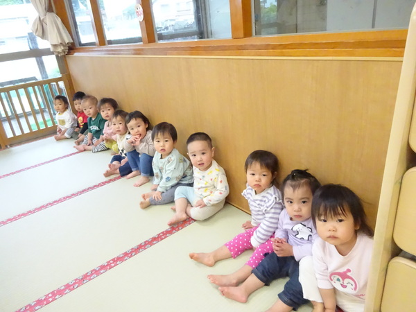 並んで座って待つ子どもたち