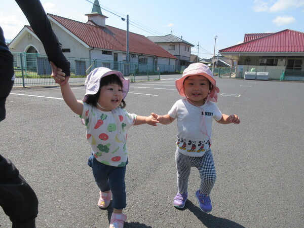 女の子が手を繋いで歩いている