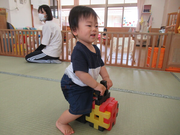 ブロックの車に乗る子ども