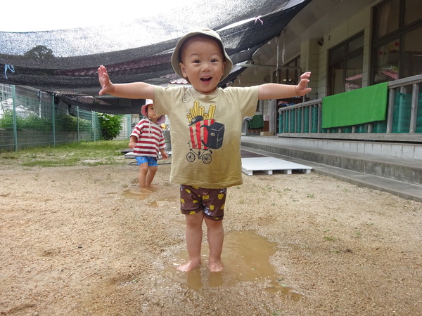 水たまりで遊んでいる男の子