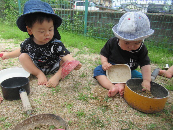 園庭で砂遊びをしている様子