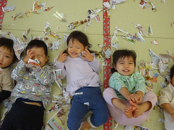 広告紙のシャワーを楽しんでいる子どもたち (2)