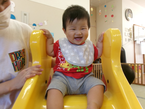 滑り台の上に座っている子ども