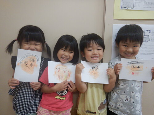 自画像を見せている子どもたち