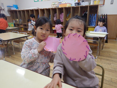 紐通ししたものを見せている子どもたち