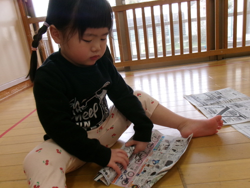 新聞紙で遊ぶ子ども