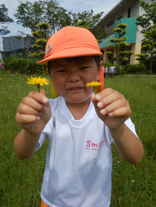 タンポポのお花を持っている子ども