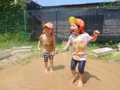 水たまりで遊ぶ子ども