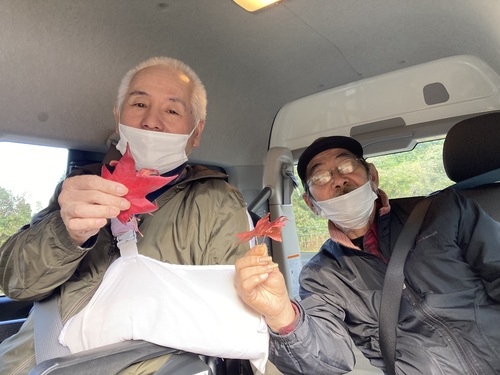 紅葉した葉を持ち記念写真