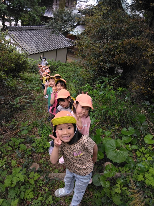 細い道を歩いて行く子どもたち